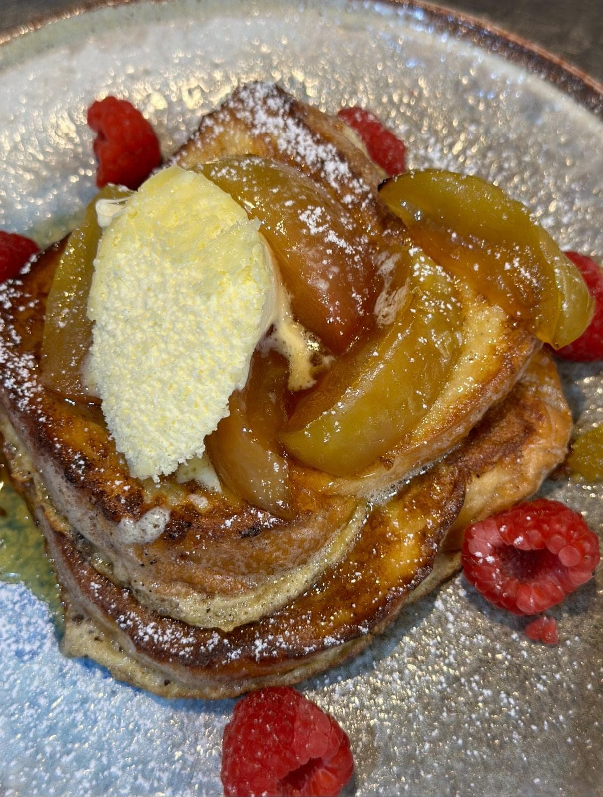 Brioche French toast with caramelised apple, clotted cream and raspberries